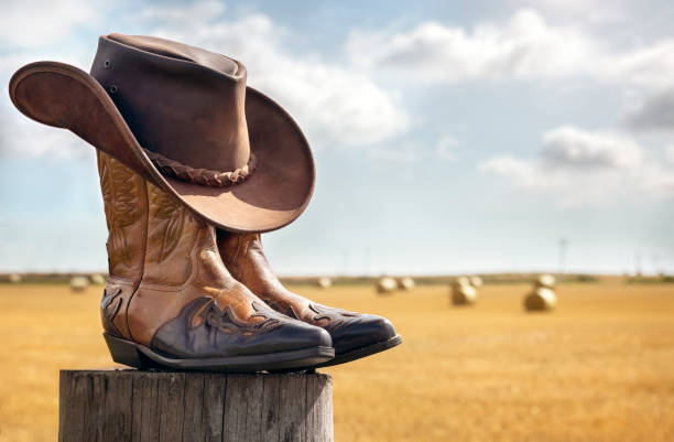Country Cowboy hat and boots with fields behind.